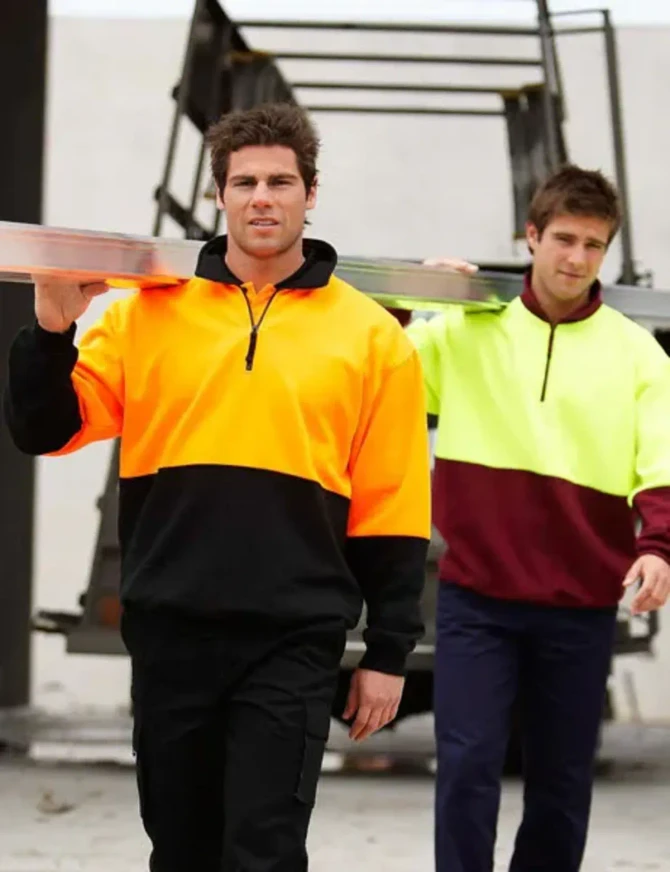 A half-zip polar fleece in bright orange and black, worn by a man carrying a ladder, with another in yellow and maroon.