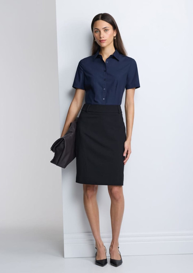 A navy short sleeve shirt paired with a black skirt, displayed on a model against a grey backdrop.