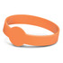 An orange silicone wristband featuring a round disc, designed to glow in the dark.