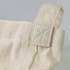 A close-up of a cream cotton shoulder tote bag, featuring a stitched handle with a cross-stitch detail.