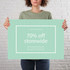 A person holds a large green sign with a white border, featuring a promotional message about storewide discounts.
