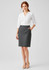 A grey women's comfort wool stretch skirt with pleats, paired with a white blouse. The model has red hair and is wearing nude heels.