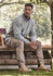 A unisex 1/4 zip brushed fleece pullover in grey, worn with khaki trousers and brown boots, featuring a logo.