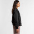 A black bomber jacket displayed on a model, featuring a sleek design and fitted silhouette.