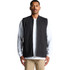A heavy black canvas vest with a zip front and two pockets, worn over a white long-sleeve shirt.