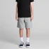 Grey track shorts shown on a model, paired with a black t-shirt and sneakers, featuring a logo on the shorts.