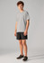 A young person wearing grey sports shorts and a grey t-shirt, paired with black athletic shoes. The shorts have a logo.