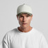 A two-tone camo cap featuring a cream body and a camouflaged brim, worn by a model.