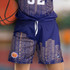 Custom women's basketball shorts in navy with a city skyline design and an emblem. Features a drawstring waist.