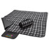 A black and grey checkered picnic rug, rolled up on one side, with a fabric logo patch visible.