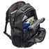 A black laptop backpack with multiple compartments, showcasing a laptop, cables, and other accessories inside.