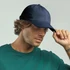 A navy organic dad hat is worn by a man with wavy hair, paired with a green shirt. The hat features a logo.