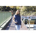 A unisex navy puffer vest worn by a model, featuring a front zip and pockets, set by a scenic outdoor backdrop.