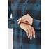 A close-up of a women's button-up shirt featuring a blue and black checked pattern, with button details and rolled sleeves.