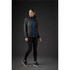 A woman wearing a black rain jacket with blue accents, paired with black leggings and sneakers.