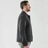 A men's jacket in dark grey, featuring a sleek design and a minimalistic look, with a logo present.