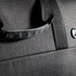 A black duffle bag featuring a textured fabric and a sturdy handle, with a logo visible on the side.
