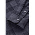 A close-up view of a dark grey plaid button-up shirt, featuring snap buttons and a neatly folded cuff.