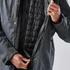 A grey men's jacket with a zippered front, featuring a quilted black lining and a person holding it open.