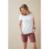 A woman wearing a white T-shirt paired with maroon shorts, featuring a logo on the T-shirt.