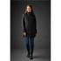 A woman models a long, black Montauk System Jacket, featuring a high collar and a fitted silhouette.