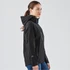 A women's black softshell jacket with a hood, featuring zippered pockets and a fitted silhouette.