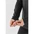 A close-up of a woman's hand adjusting the cuff of a long-sleeve grey crew neck shirt.