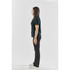 A side view of a woman wearing a black women's polo shirt and black pants, with a logo on the shirt.