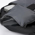 A grey backpack with a laptop compartment and a black mouse nestled inside. It features a branded logo.