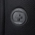 A close-up of a black mesh fabric featuring a round logo patch.