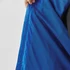 A close-up of the interior lining of a blue rain jacket, showing a textured fabric and a hands holding the jacket.