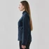 A softshell jacket in navy blue, featuring a zip pocket, shown from the side on a model with long hair.