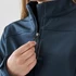 A navy women's softshell jacket with a zippered front, featuring a hand adjusting the zipper.