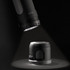 A black Swiss Peak 4-in-1 speaker illuminated by a flashlight, showcasing its sleek design and functionality.