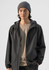 A grey rain jacket is worn by a person with dark hair, complemented by a grey beanie and a beige shirt underneath.