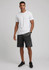 A model wearing black sports shorts and a plain white t-shirt, standing against a neutral background.