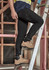 Mens lightweight outdoor cargo pants in black, worn by a person standing on a ladder, featuring a logo.