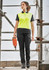 A woman wearing bright yellow and black cargo pants, standing on scaffolding with a power tool, showcasing the cargo pant design.
