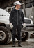 A man wearing a black unisex zip front multi-pocket hoodie, gloves, and work boots, standing next to a white vehicle.