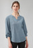 A blue women's long sleeve blouse with a V-neck and ruché detailing. The fabric has a textured look.