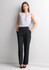 A woman wearing black soft stretch pants paired with a light grey top, standing against a plain background.