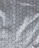 A close-up of a light grey fabric featuring a hexagonal pattern, typical of graphene puffer jackets.