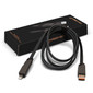 A black data and charging cable with a braided design, laying next to its packaging that includes a logo.