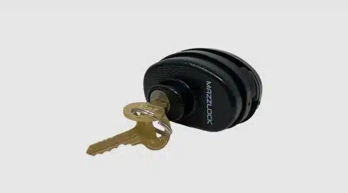 Angled studio shot of black Mazzlock TL415 keyed universal trigger lock with a brass key inserted in the keyhole