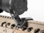 Magpul MBUS Pro offset front sight mounted on a tan picatinny rail next to a black riflescope lens cover