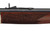Close-up of an engraved wooden forearm on a rifle showing detailed scrollwork around the Henry brand name.