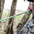 Bowhunter in full camouflage drawing back a compound bow in the woods with a green nock arrow loaded