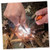 Hands using the Outdoor Edge Ignitro knife blade to strike the fire starter rod creating bright survival sparks