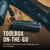 Close-up lifestyle view of a folded black Leatherman multi-tool on a wood bench with text reading Toolbox On-The-Go