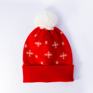 Flat lay of red snowflake pom beanie with blank cuff